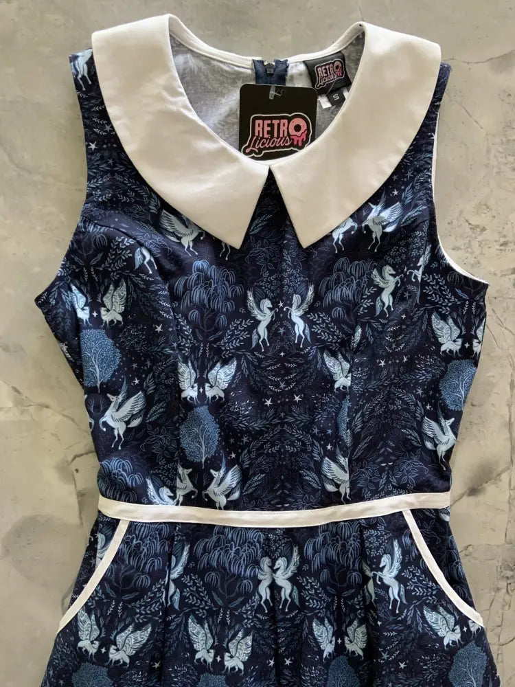 A navy blue sleeveless cotton a-line dress with a white peter pan collar and unicorn print with pockets