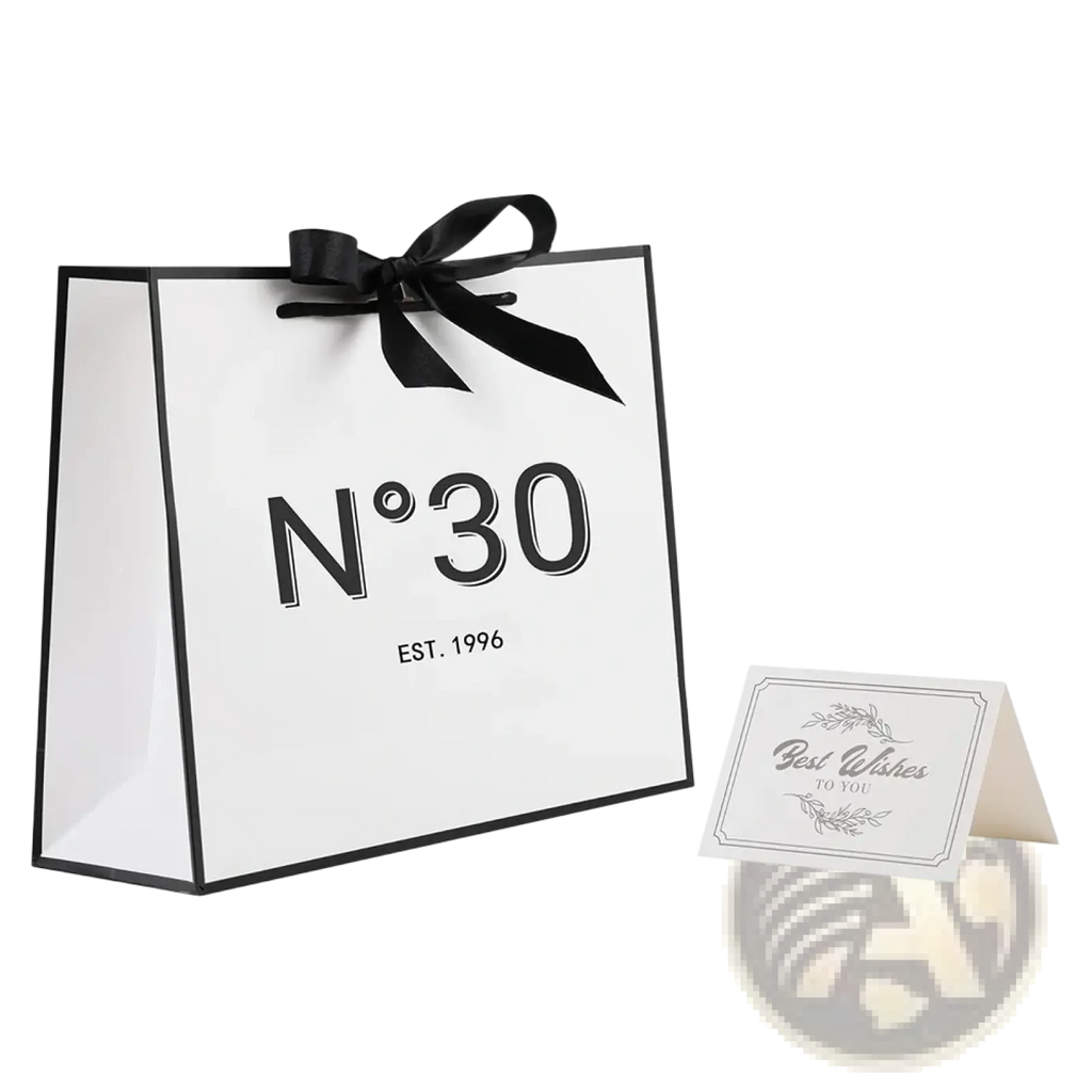 White paper shopping bag with black trim satin ribbon bow and n°30 logo for milestone birthday gift with card