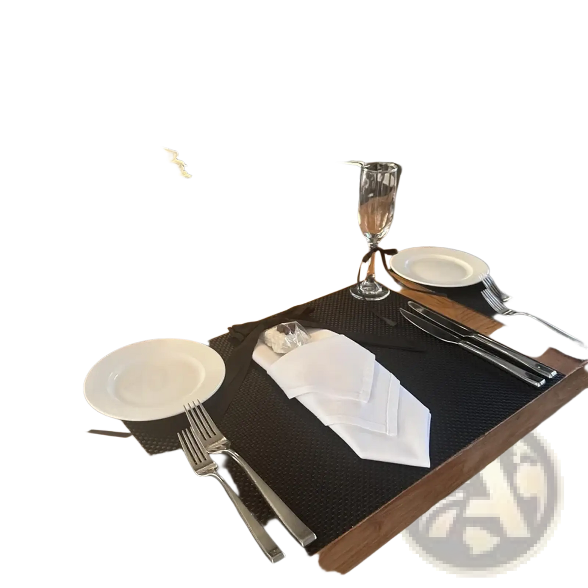 Black textured placemat with silverware and white napkin arranged for milestone birthday gift bag with card and ribbon