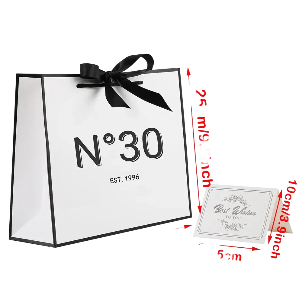 White paper shopping bag with black trim and satin ribbon bow featuring n°30 est for milestone birthday gift use
