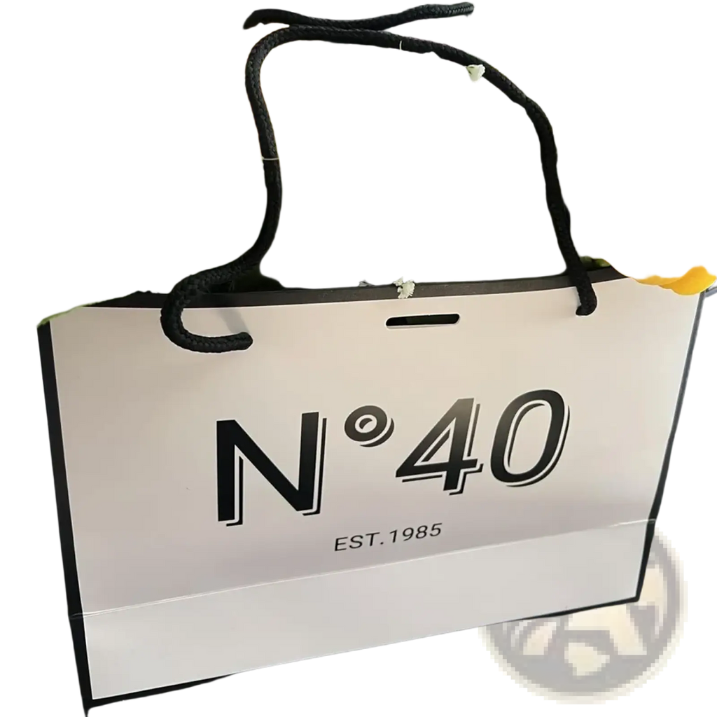 White paper shopping bag with black handles and bold n40 branding for milestone birthday gift with card and ribbon