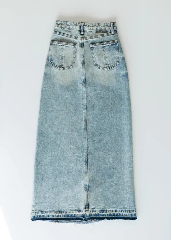 Back side of mina frayed hem light wash denim midi skirt with classic pockets and frayed hem detail