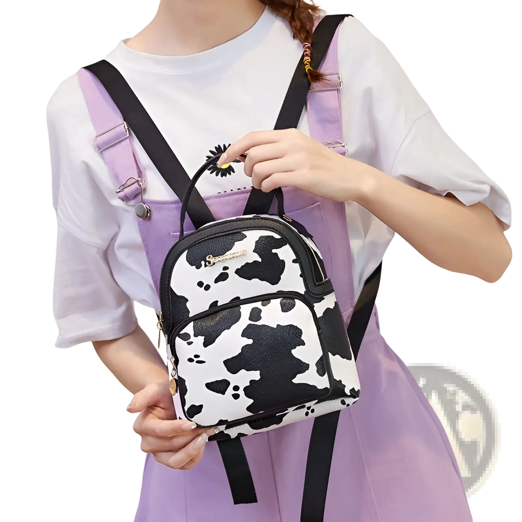 Mini backpack with a black and white cow print design and adjustable straps in korean style materials