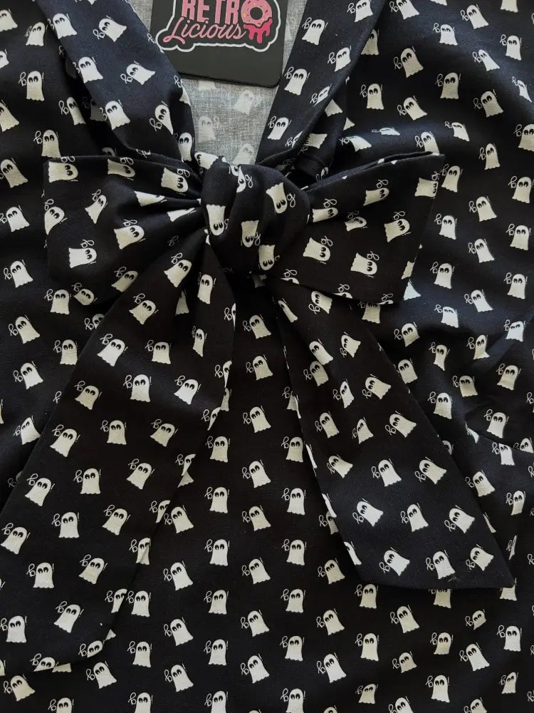 Black sleeveless blouse with white ghost prints and large bow neckline in mini ghosts retro style
