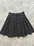 Black high waisted pleated skater skirt with repeating white ghost pattern featuring mini ghosts design