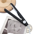 Mini portable ceramic hair straightener and curler in black and silver with a white power button