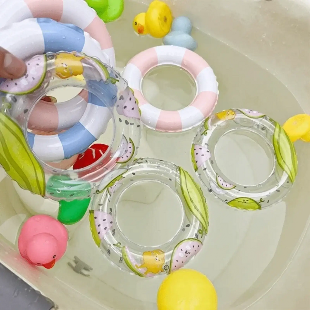 Mini turtle inflatable swim ring made of clear material with colorful fruit and cartoon duck designs floating in water