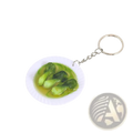 Miniature food keychain with a white plate of green bok choy leaves in light yellow broth on a silver chain ring