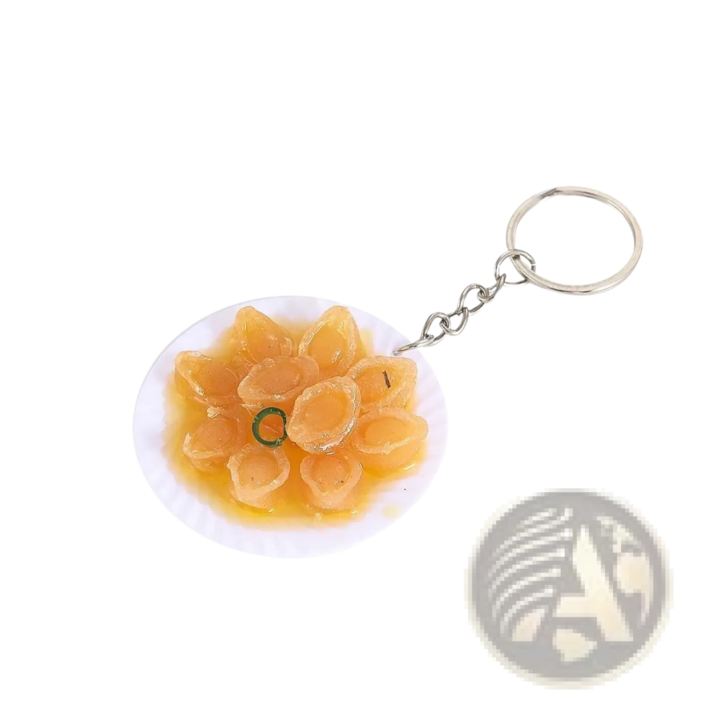 Miniature food keychain featuring detailed golden-brown dumplings on white plate with silver chain and ring
