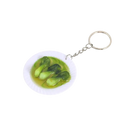 Miniature food keychain with a white plate of green bok choy leaves in light yellow broth on a silver chain ring