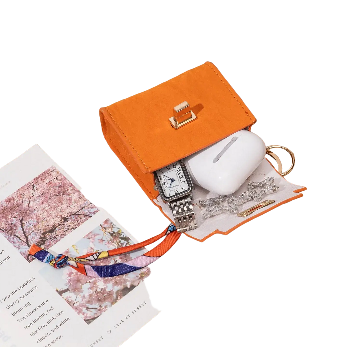 Orange faux leather miniature handbag keychain with gold-tone clasp and white interior lining featuring silk scarf