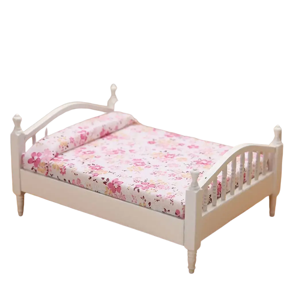 White miniature wooden dollhouse bed with floral pink and cream patterned bedding for decorative use