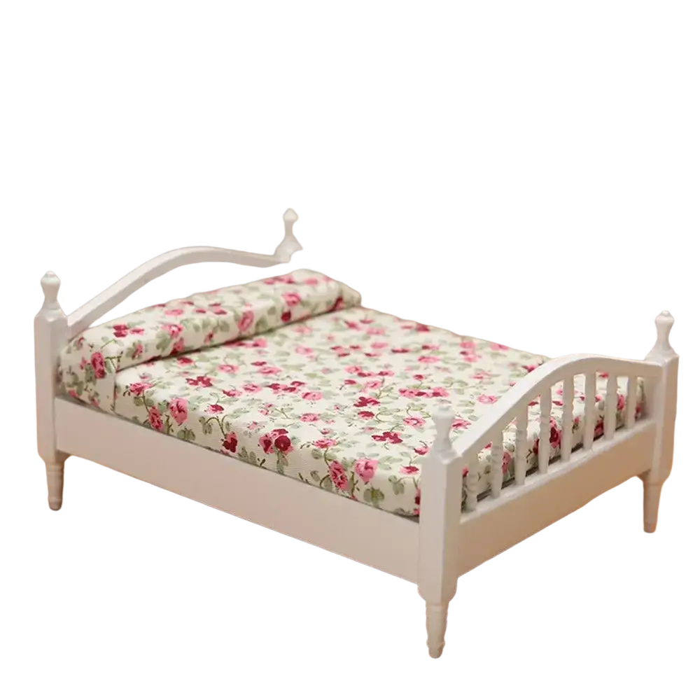 Miniature wooden dollhouse bed in white with floral pink and green bedding for decorative use