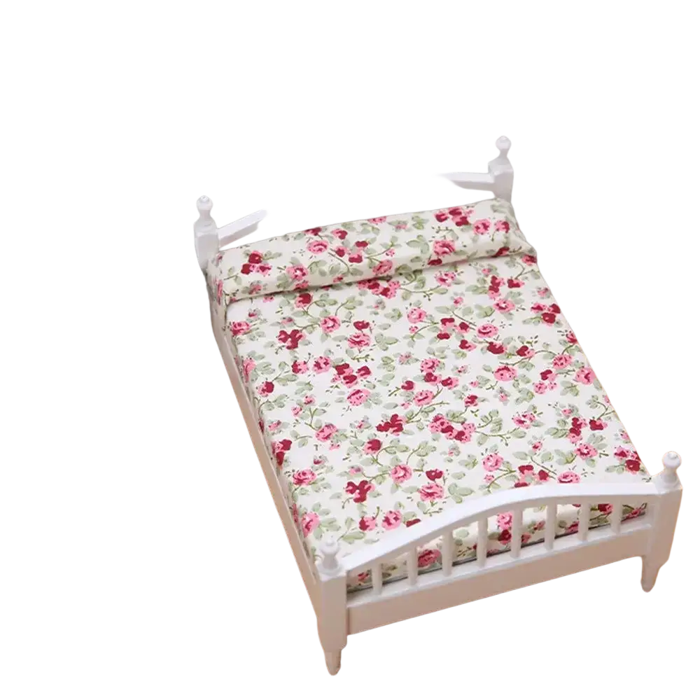 White miniature wooden dollhouse bed with pink and green floral bedding for decorative display