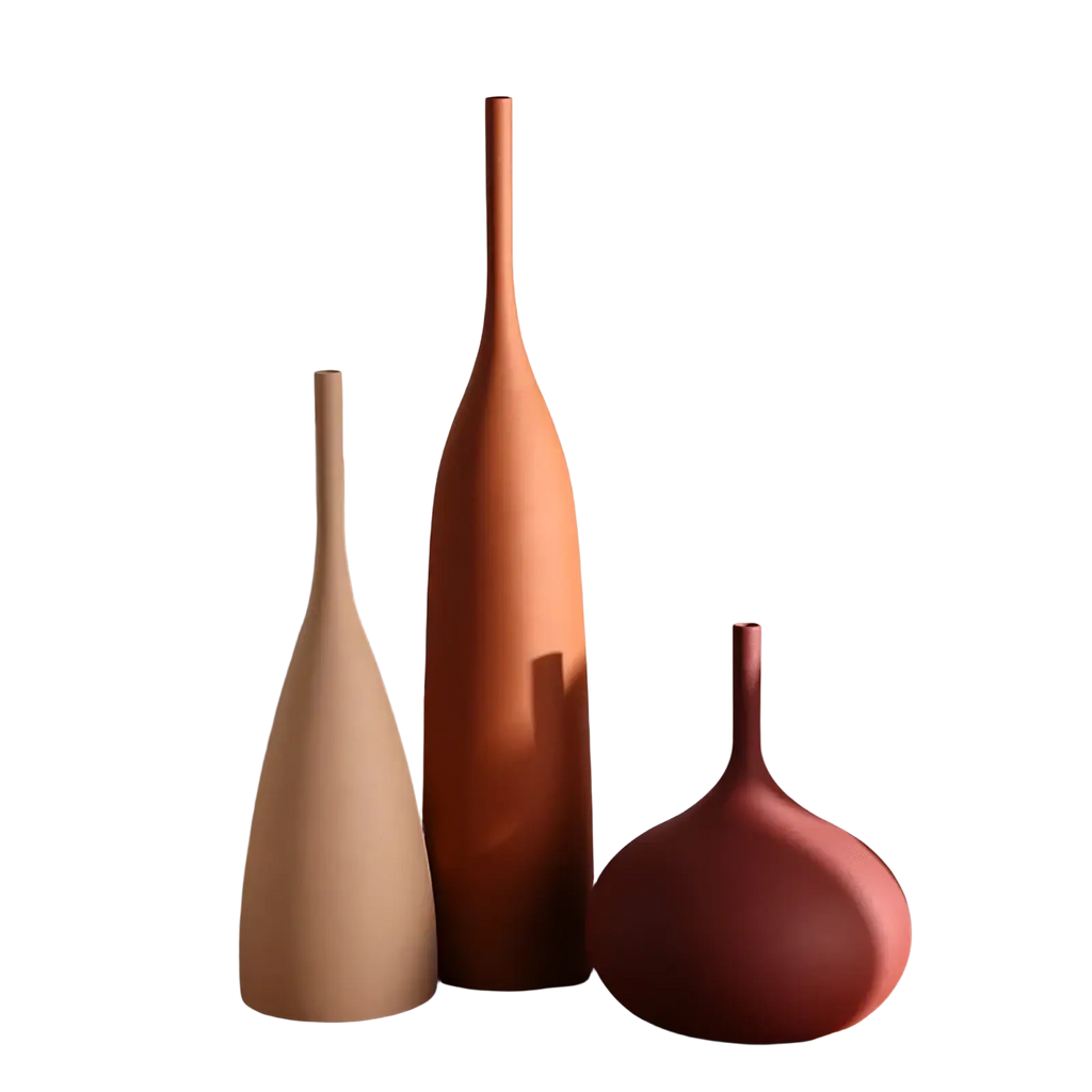 Three minimalist ceramic vases in beige terracotta and muted rose arranged on a wooden surface for wabi sabi decor