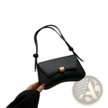 Minimalist black faux leather crossbody bag with gold-tone rectangular clasp and knotted strap for structured style