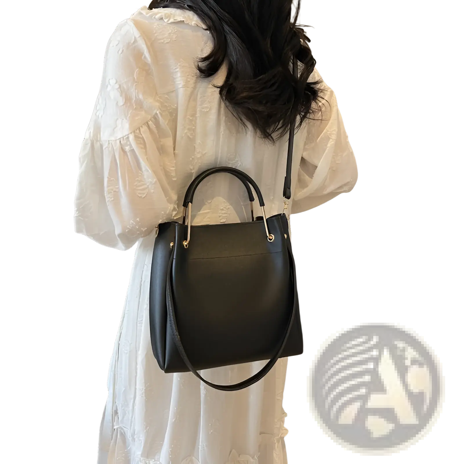 Minimalist black leather bucket bag with gold-tone hardware, top handle, and detachable strap for versatile use