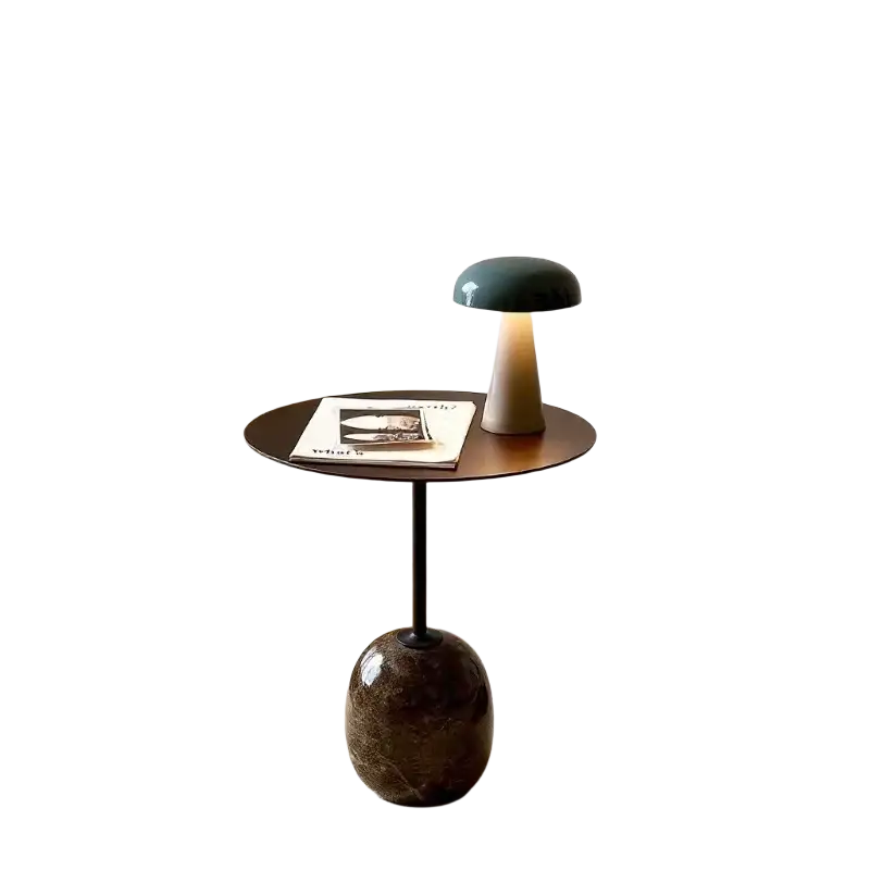 Minimalist marble metal round side table next to a mushroom-shaped table lamp with a matte dark green ceramic shade and beige base