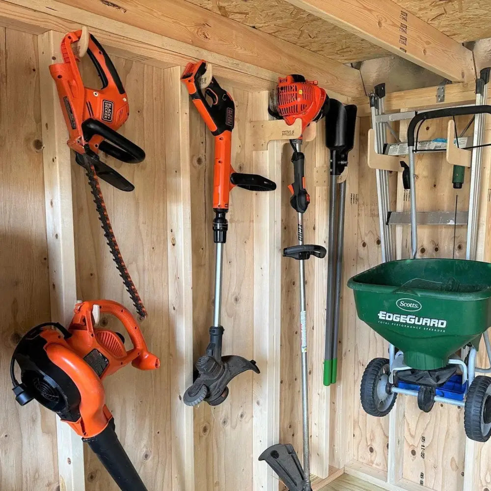 Heavy duty compact stud mounted power tool storage hook holding an orange and black black & decker hedge trimmer with serrated blade on wooden wall