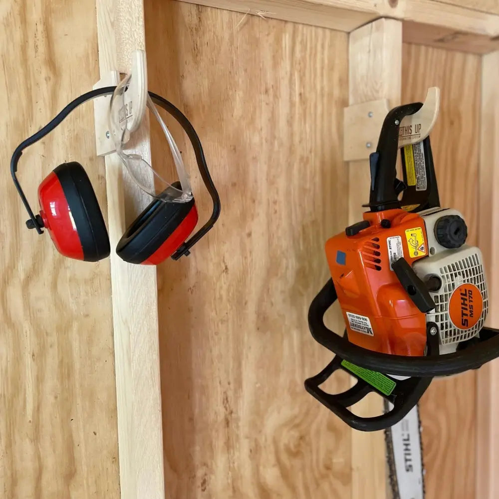 Heavy duty compact stud mounted power tool storage hook holding an orange and white Stihl ms 170 chainsaw with black handle