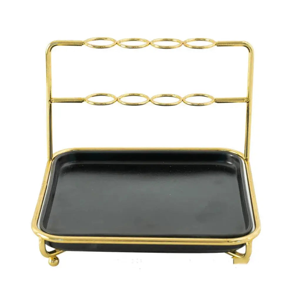 Modern gold and ceramic vanity cosmetics organizer featuring a gold-toned metal barware rack with black tray and ring holders