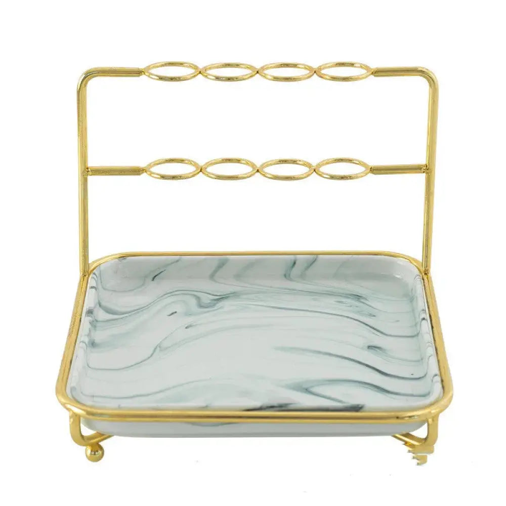 Modern gold and ceramic vanity cosmetics organizer with a gold-toned metal frame and rectangular marble-patterned tray