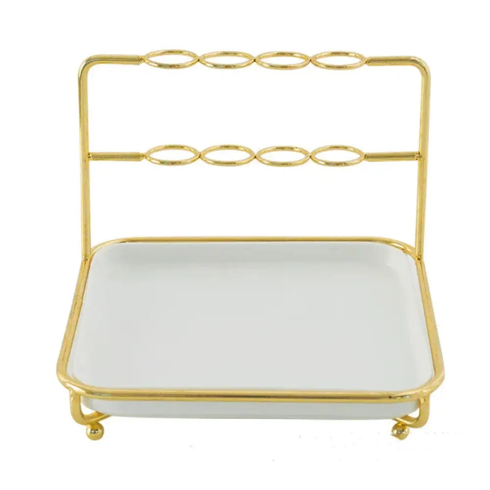 Modern gold and ceramic vanity cosmetics organizer with gold-toned metal frame and white ceramic tray on four feet