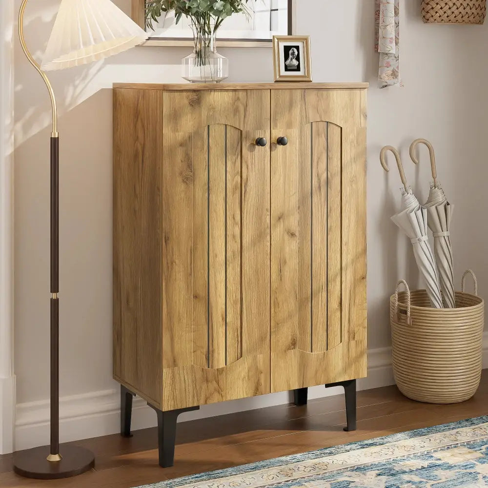 Modern light brown double door shoe cabinet with arched panel doors and black metal legs in light wood finish