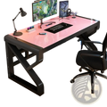 Modern glass office desk with pink glass top and black frame featuring storage shelves for organized workspace