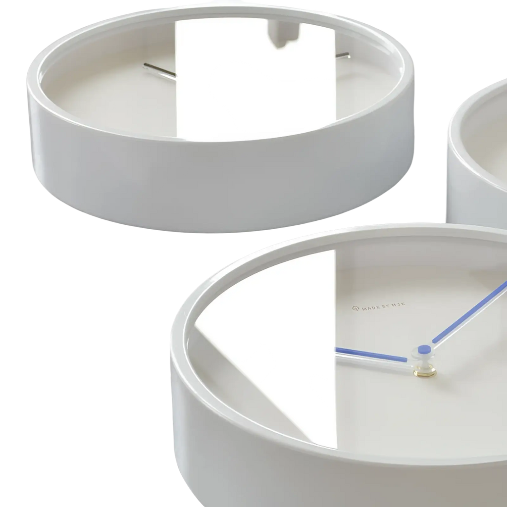 White circular metal wall clock with minimalist blue hands and mirrored face for modern living room decor