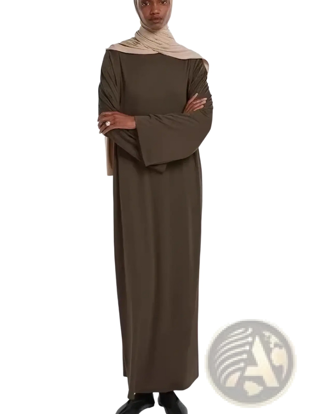 A woman wears a long olive green modest abaya with flared sleeves and a beige hijab suitable for prayer