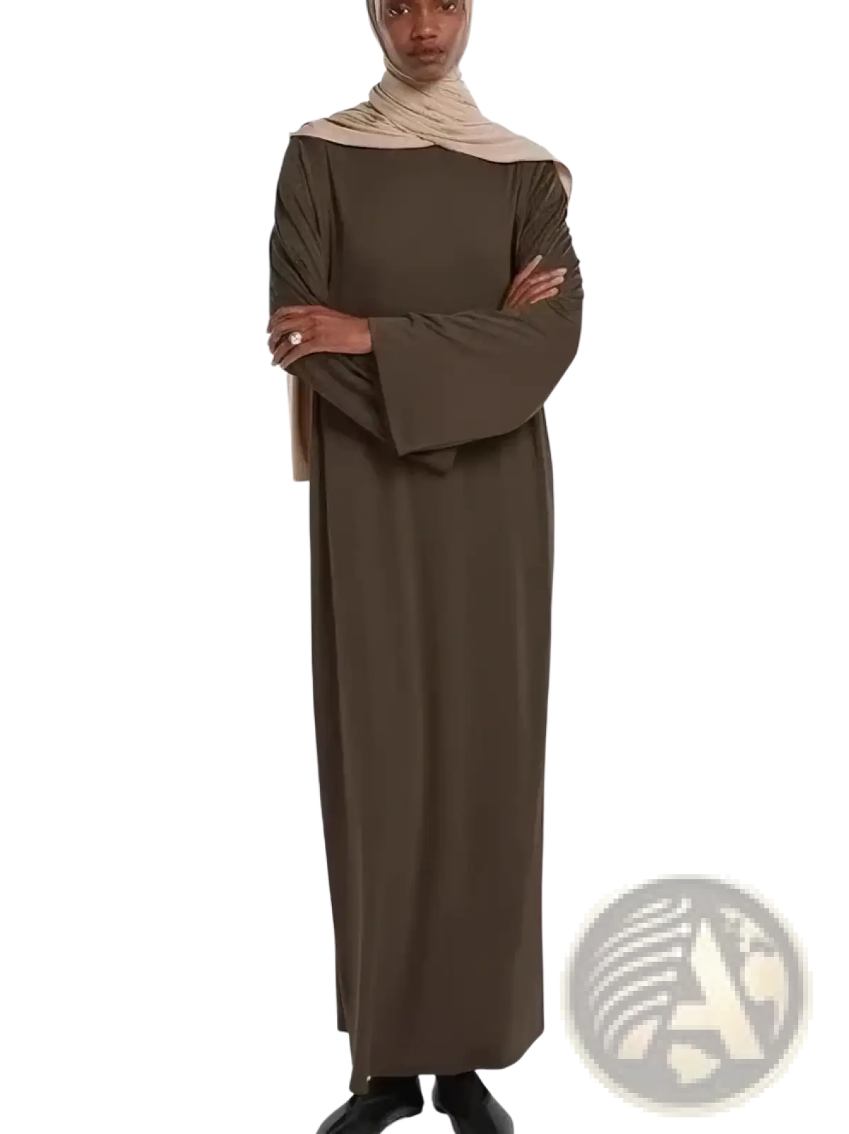 A woman wears a long olive green modest abaya with flared sleeves and a beige hijab suitable for prayer