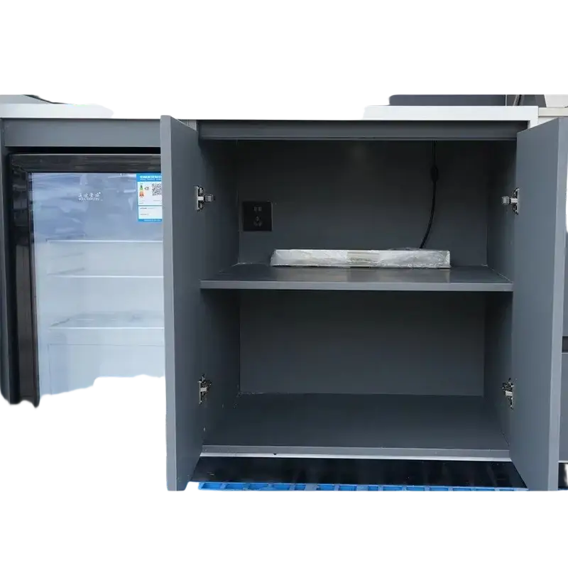 Gray metal outdoor cabinet with open doors showing built-in refrigerator and empty shelves for modular kitchen use