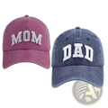 A pair of distressed cotton baseball hats in muted pink mom and faded blue dad lettering for couples