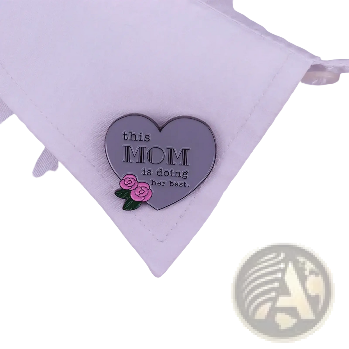 A heart-shaped pink enamel pin with this mom is doing her best inscription and roses on a white shirt collar