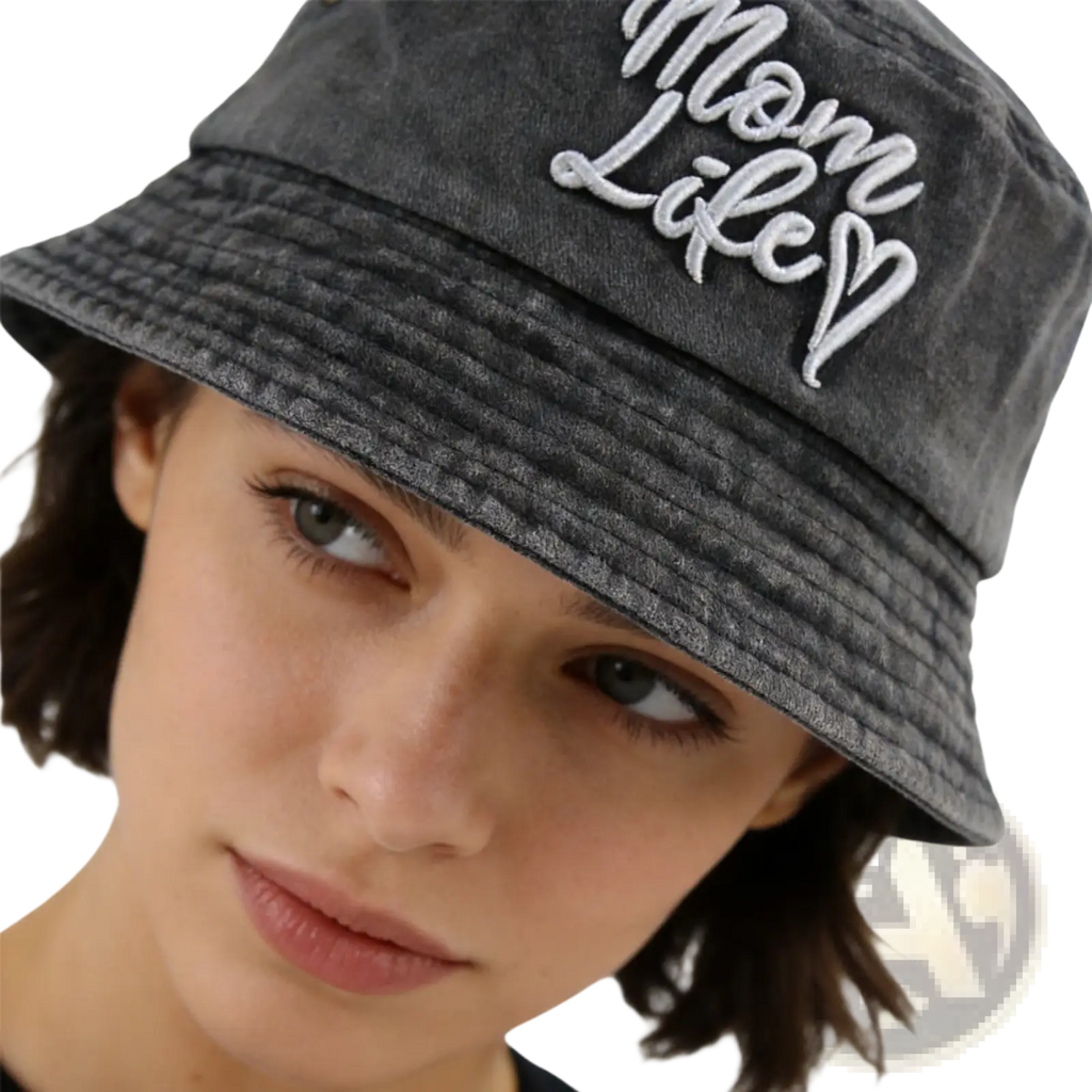 A dark gray washed cotton bucket hat with mom life embroidered in white cursive script on the front