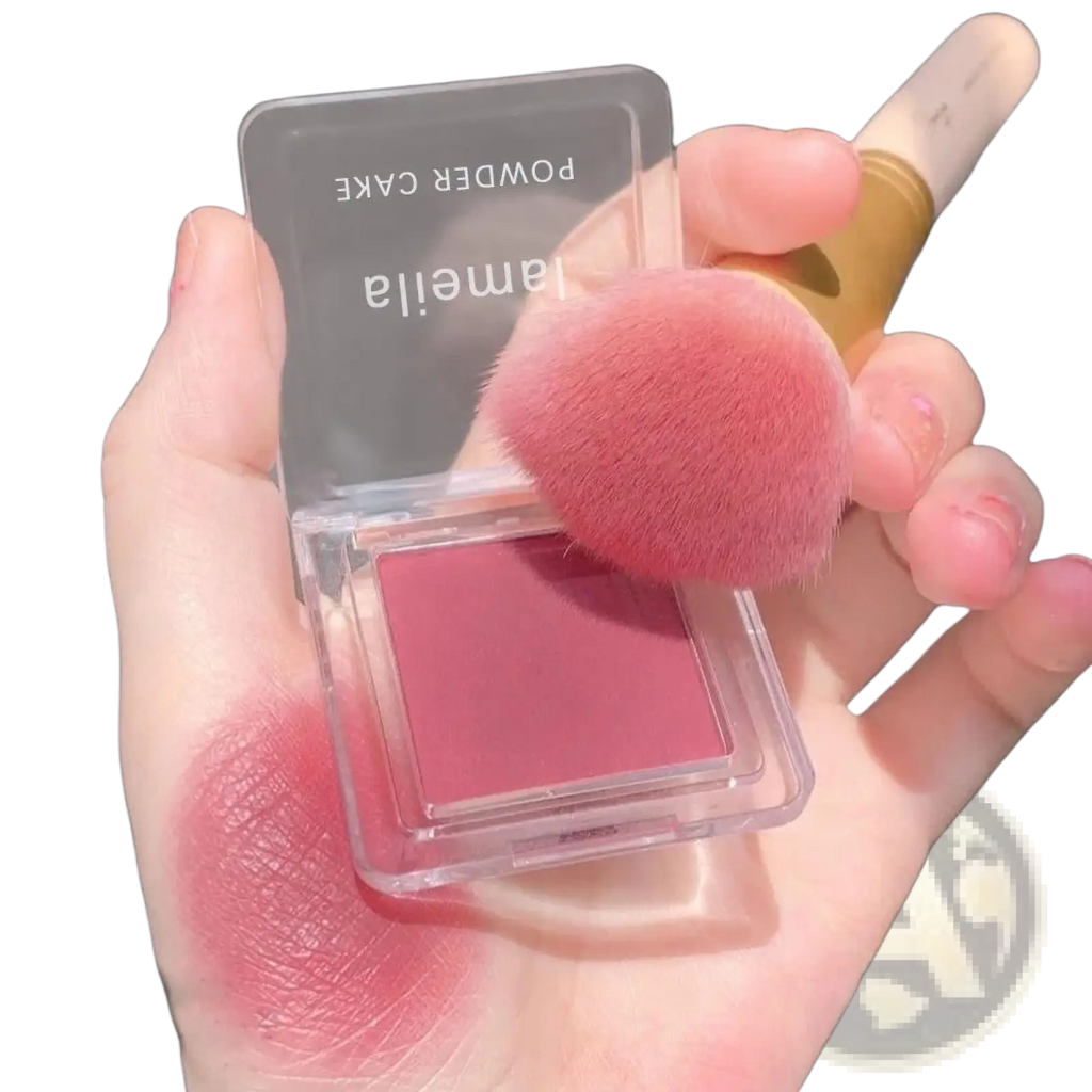 A translucent square compact of Lameila powder cake blush in soft rose pink with attached fluffy brush from Monochrome Powder Blush Compact with Brush 4 Colors