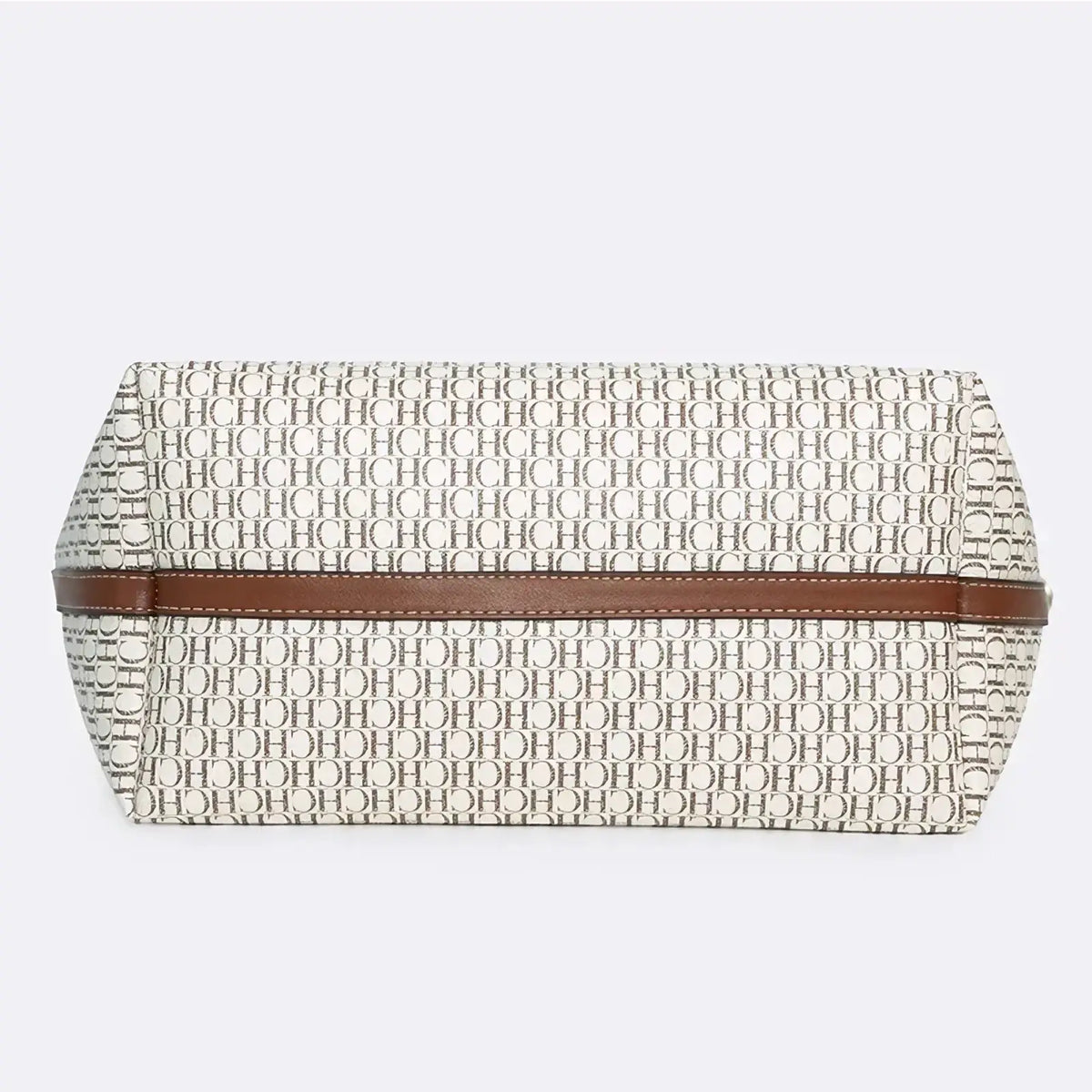 Beige and black monogram tote bag with large capacity and brown leather strap shown as a clutch accessory