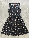 Black sleeveless cotton midi dress with flared skirt featuring gold and white moon phase pattern vintage celestial design