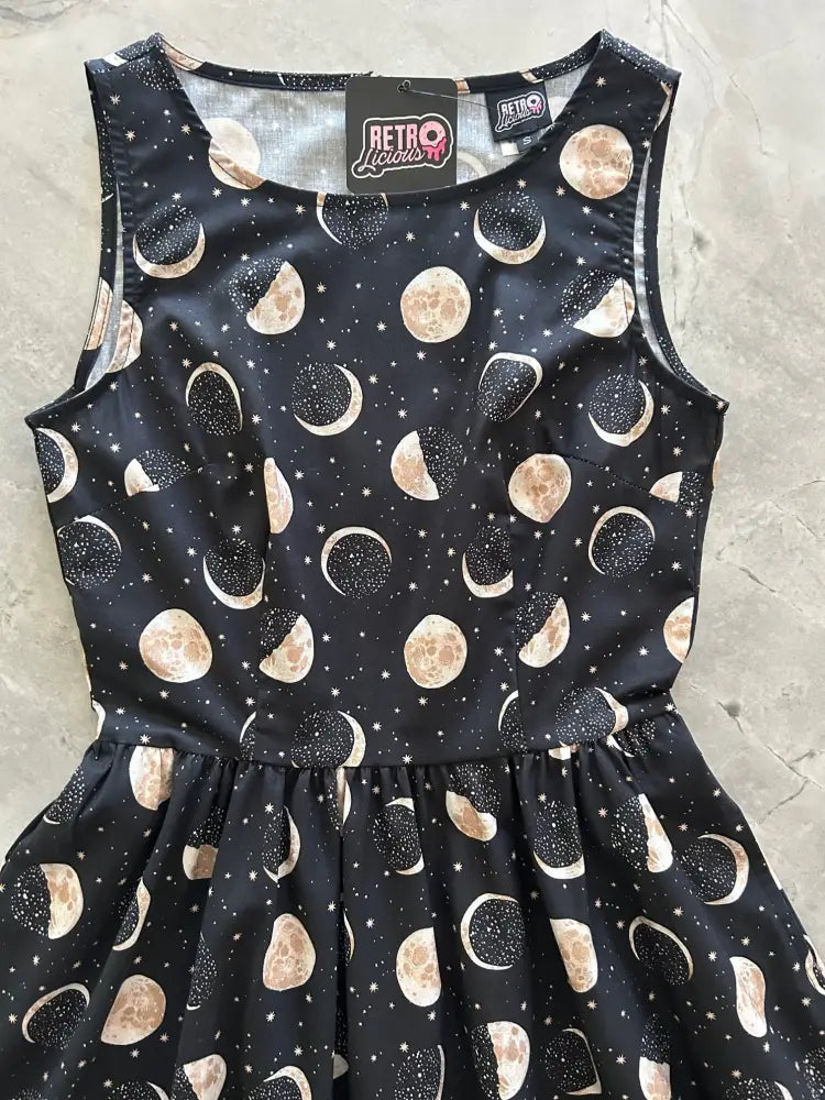 Black sleeveless vintage moon phase celestial cotton midi dress with full skirt featuring gold and white moon pattern