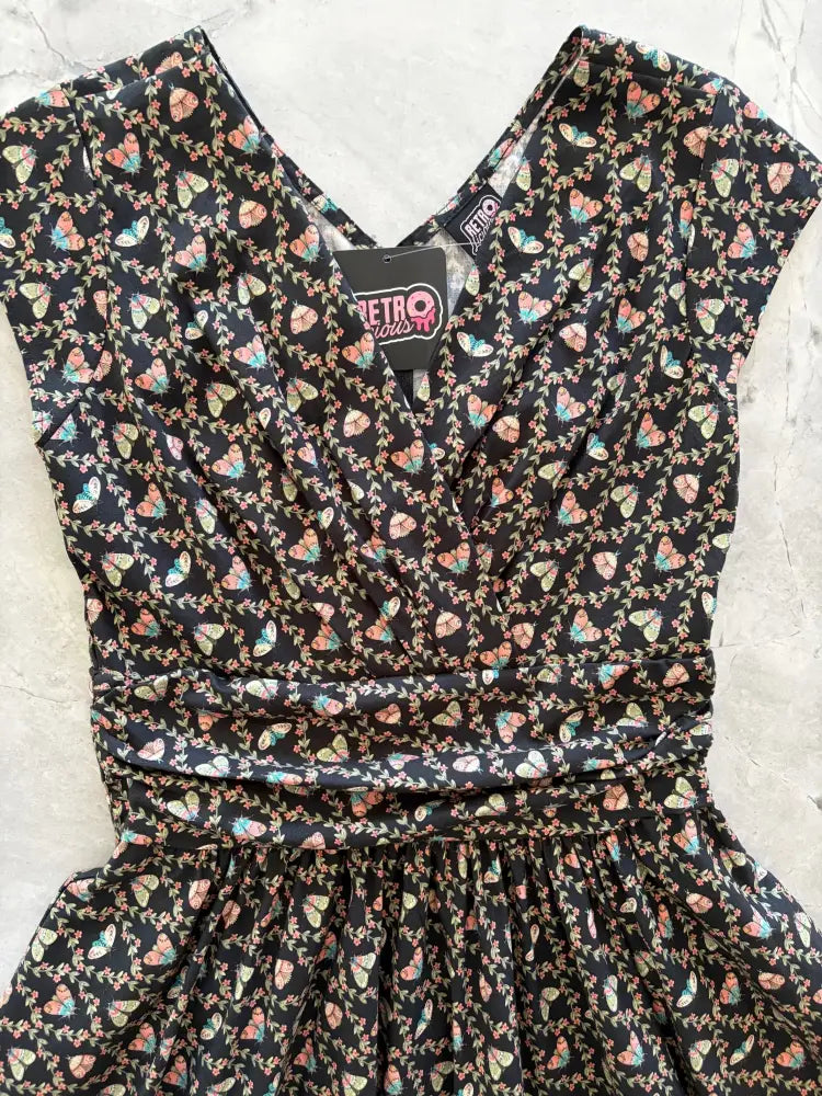 Moth greta black floral cotton wrap dress with pockets features a black v-neckline and short sleeves with pastel butterflies and vines