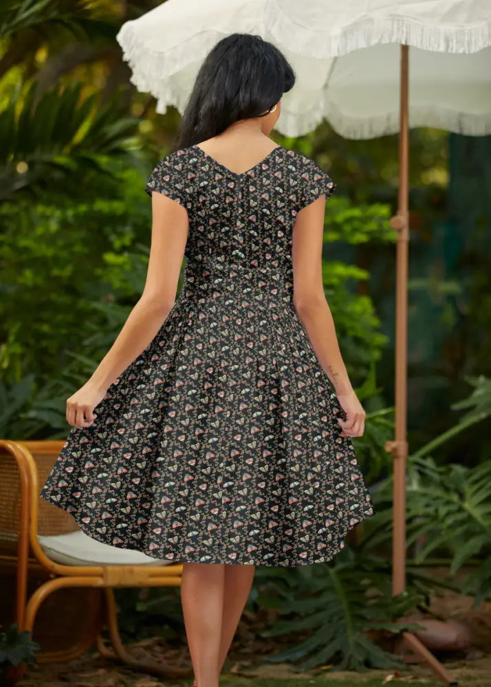 Moth Greta black floral cotton wrap dress with pockets featuring delicate pink and white flowers and short sleeves