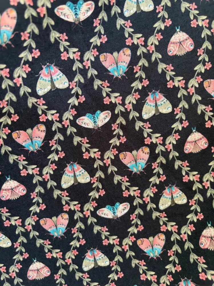 Black floral cotton wrap dress with pockets featuring colorful butterfly and pink flower pattern on black fabric