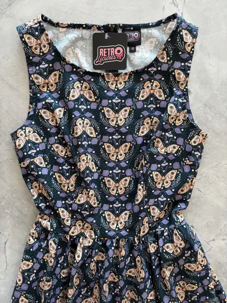 A sleeveless navy cotton midi swing dress with beige and purple butterfly print by Retro Liquor