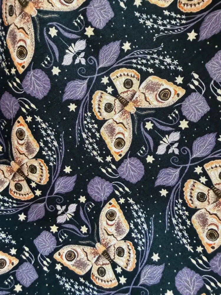 Dark navy cotton midi swing dress featuring a vintage moth print with beige and brown moths, purple leaves, and white stars