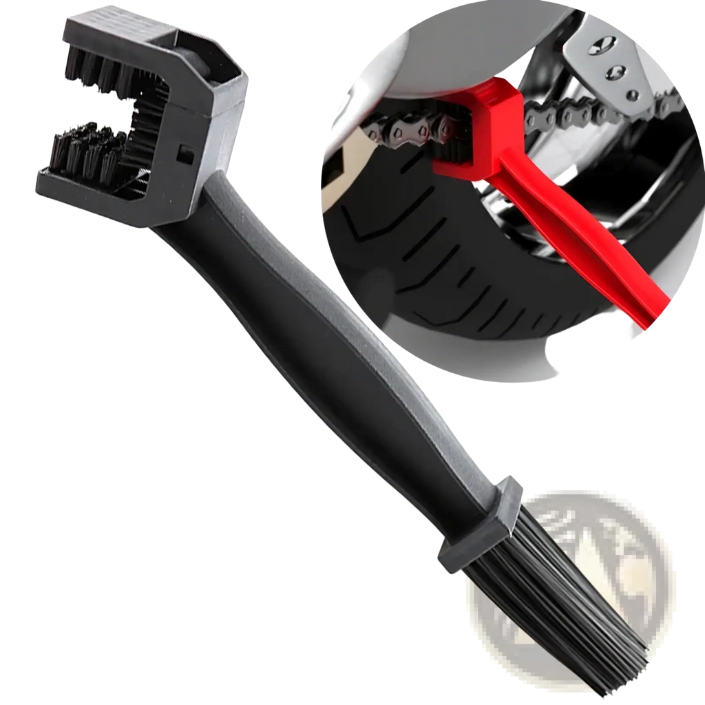 Black plastic motorcycle chain brush cleaner tool with dual-sided bristle heads and a red handle in use on bike chain