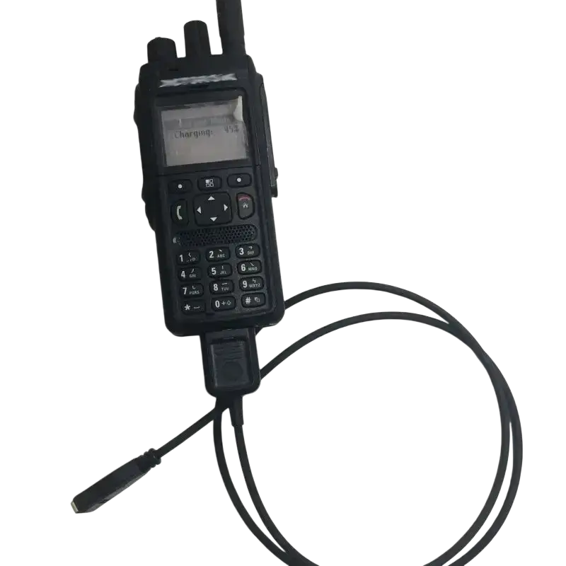 Black Motorola Tetra Mtp3150 handheld two-way radio with numeric keypad and antenna connected to a 12v car charger