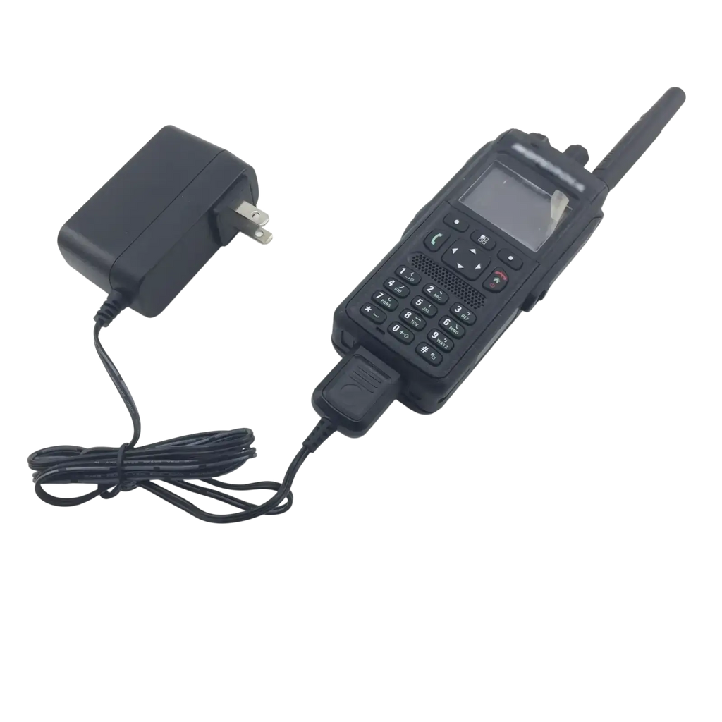 Black rugged motorola tetra mtp3150 handheld radio with numeric keypad connected to matching 12v car charger adapter