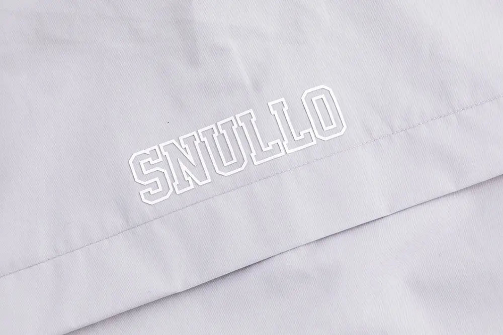 White snulllo logo embroidered in contrasting thread on light gray fabric of professional mens tactical mountaineering assault jacket