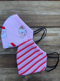 Pink reversible cotton face mask with red and white candy stripes featuring cartoon Mr and Mrs Claus characters
